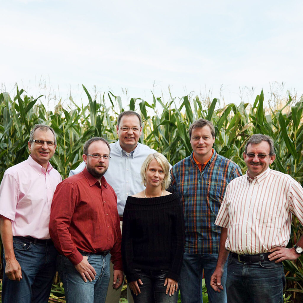 Swen Wolke und Ludwig Feldmeier mit den ersten Mitarbeitenden auf einem Maisfeld